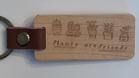 Wooden keychain with leather strap and engraved text