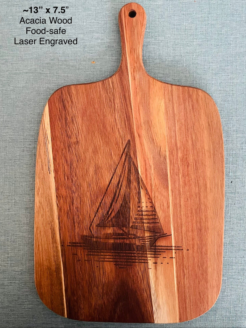 Wooden cutting board with sailboat design background